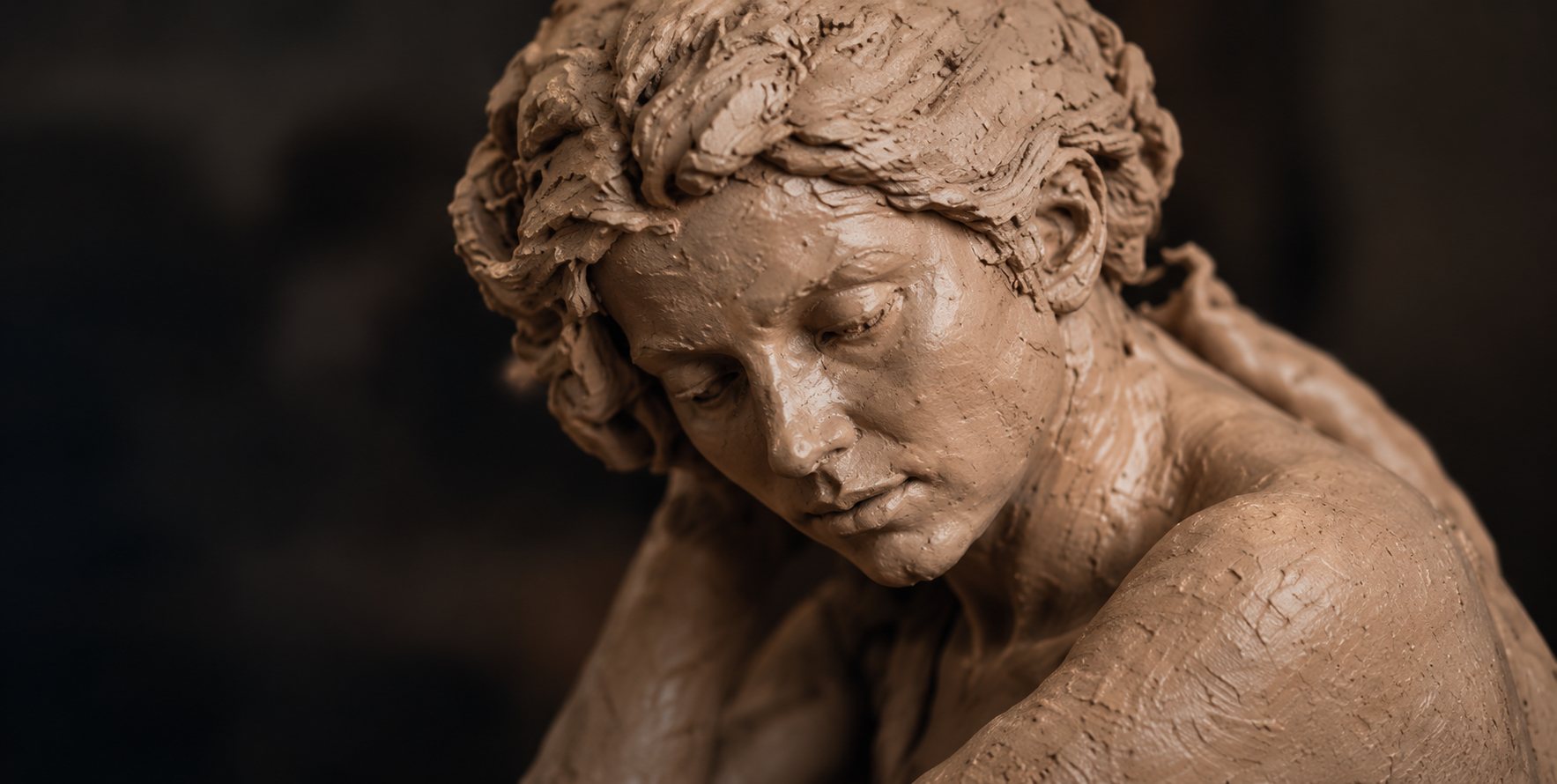 Kleibeeld van een vrouwenfiguur die naar beneden kijkt